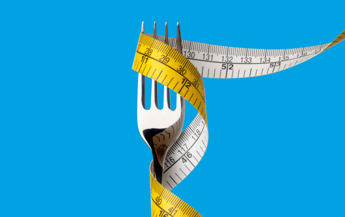 Fork with tape measure wrapped around with blue background