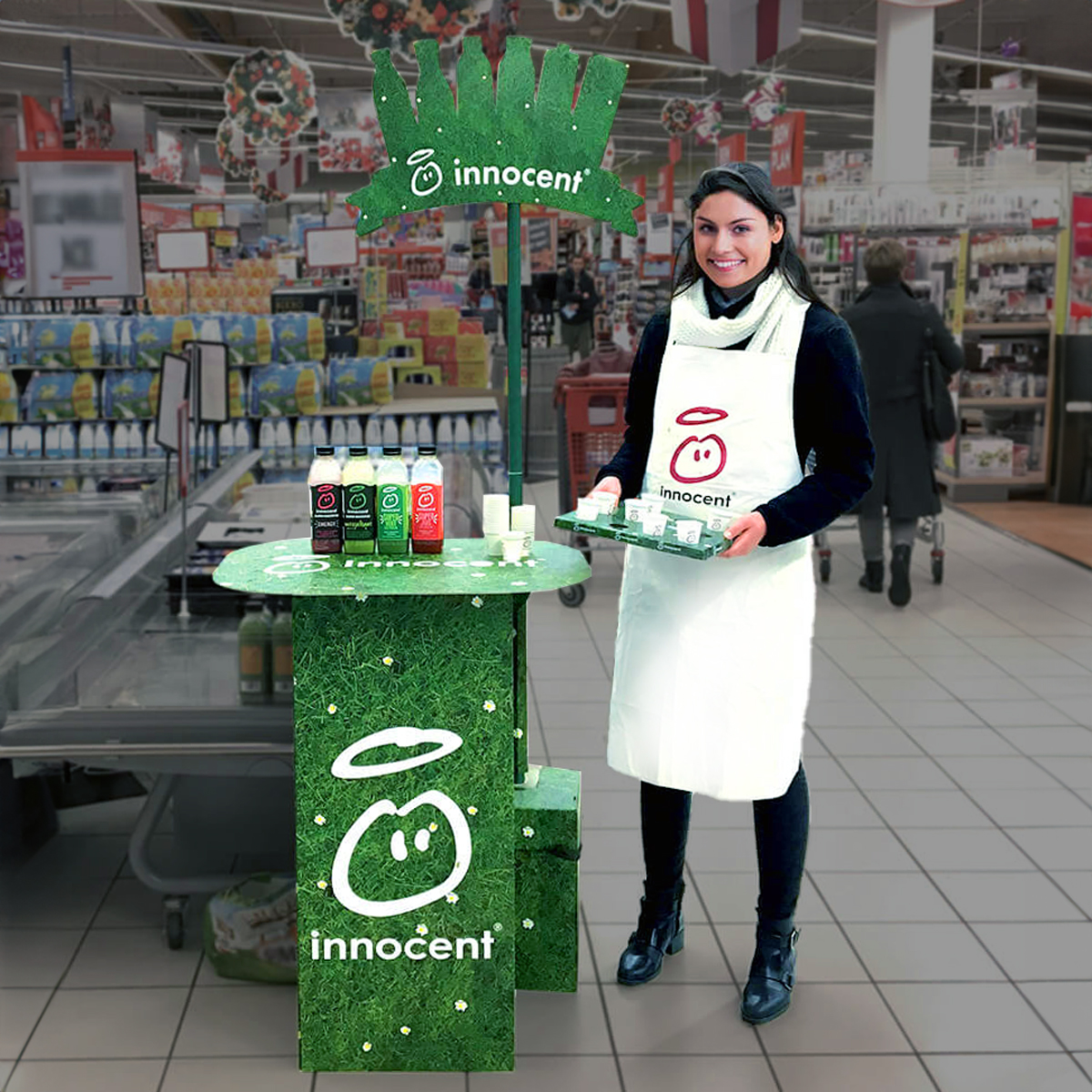 Employee standing next to an in-store display for free product samples