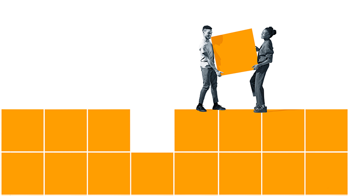 Two people placing carrying a large orange block